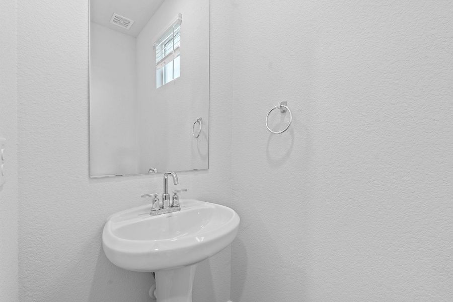Bathroom with a sink and a textured wall Bathroom with a sink and a textured wall