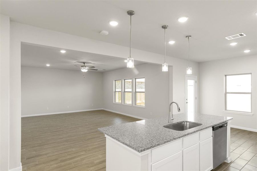 Kitchen with light wood-type flooring, dishwasher, a ceiling fan, pendant lighting, and a sink