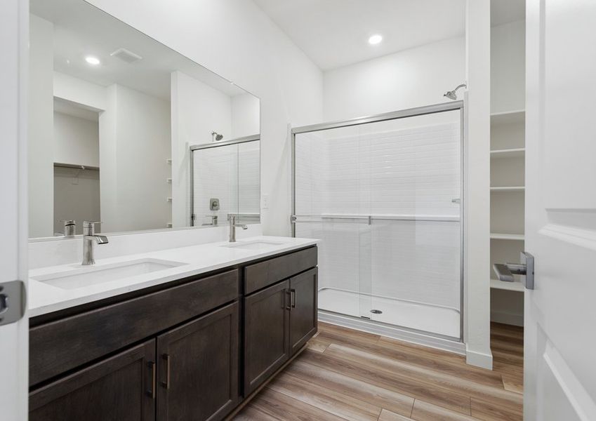 The master bathroom features dual-vanity sinks and a glass-enclosed shower.