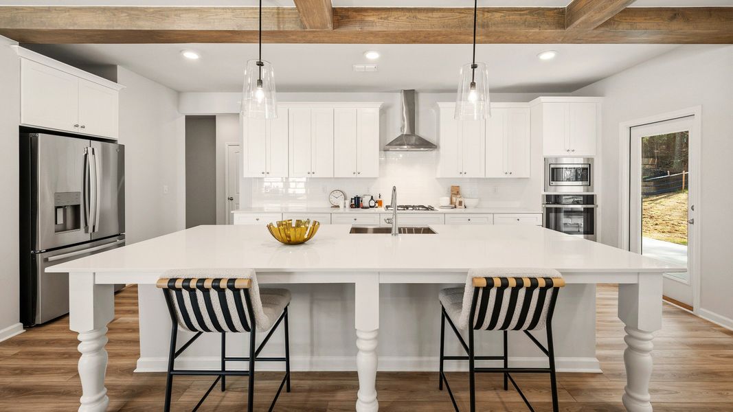 Kitchen with tile backsplash, quartz countertops, and pendant lighting Kitchen with tile backsplash, quartz countertops, and pendant lighting