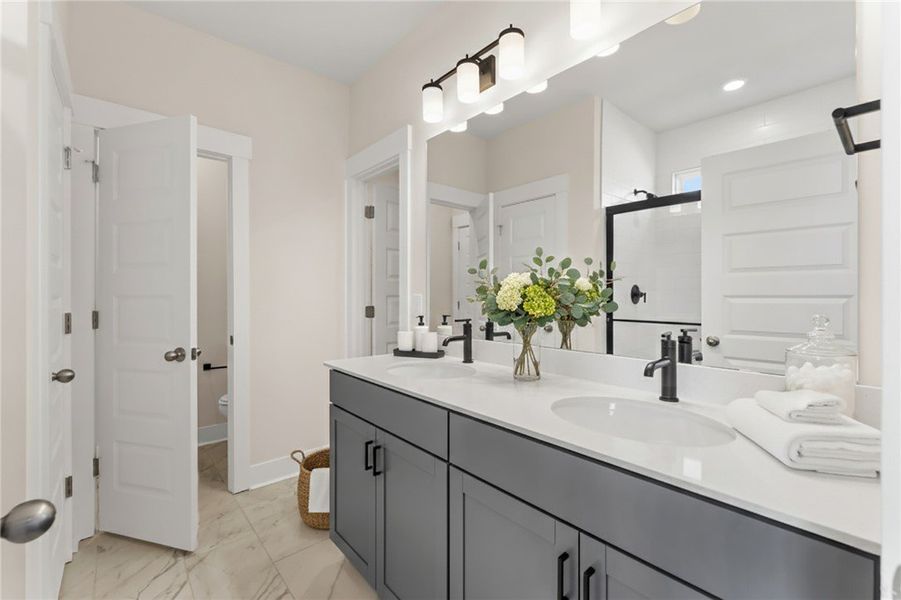 This sleek bathroom features a double vanity and s