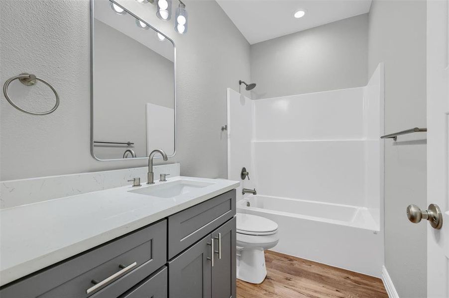 Full bathroom featuring vanity, shower / bathing tub combination, wood-type flooring, and toilet