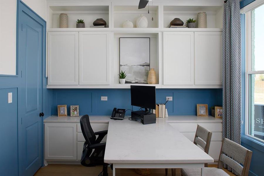 Office space featuring built in desk and light wood-style flooring
