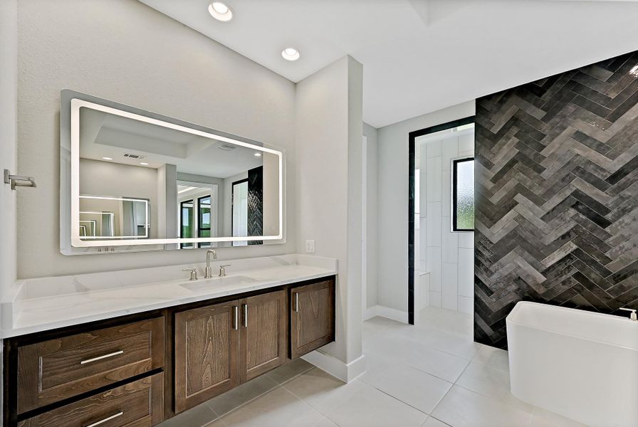 A well-lit bathroom with a modern vanity and a striking herringbone accent wall. A well-lit bathroom with a modern vanity and a striking herringbone accent wall.