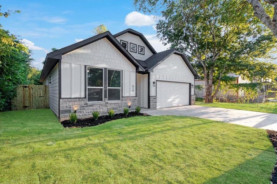 View of front of house with a garage and a front lawn