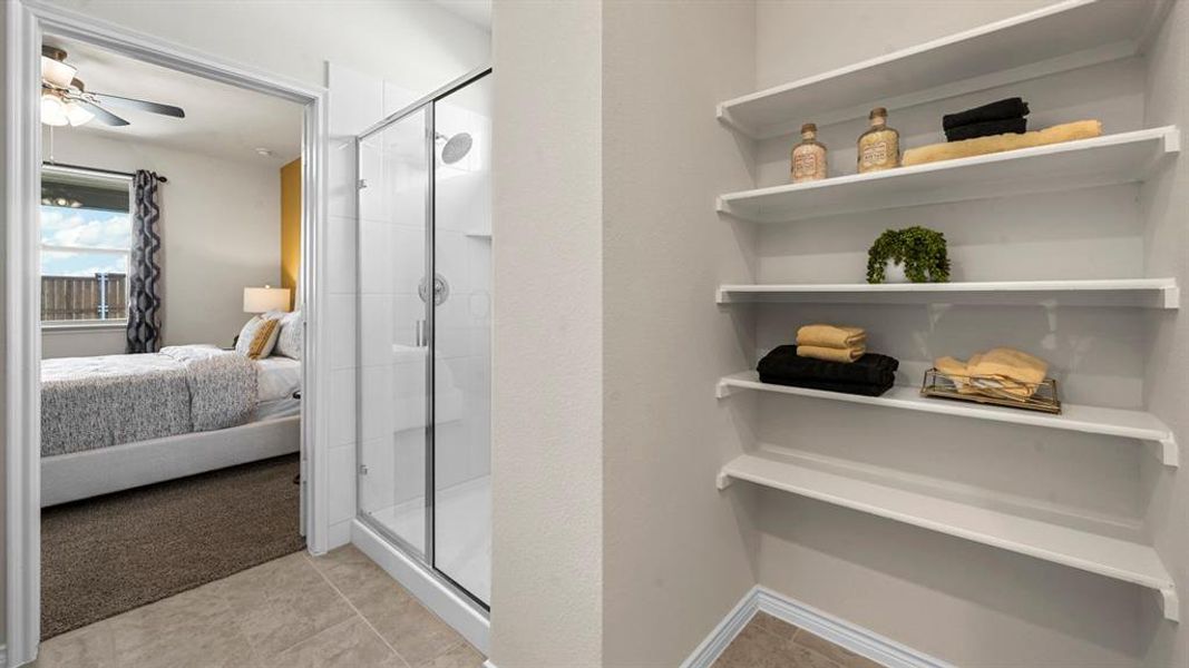Full bath featuring connected bathroom, a stall shower, a ceiling fan, and light colored carpet Full bath featuring connected bathroom, a stall shower, a ceiling fan, and light colored carpet