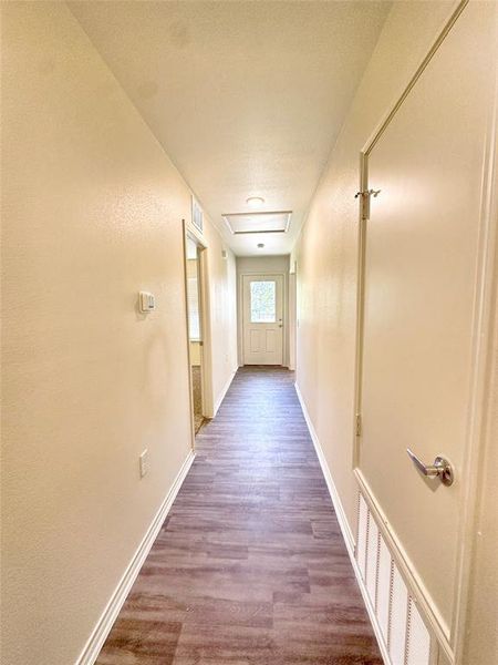 Corridor with wood-type flooring and a textured ceiling