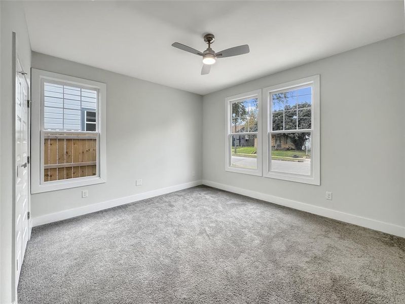 Empty room featuring carpet, plenty of natural light, and ceiling fan Empty room featuring carpet, plenty of natural light, and ceiling fan
