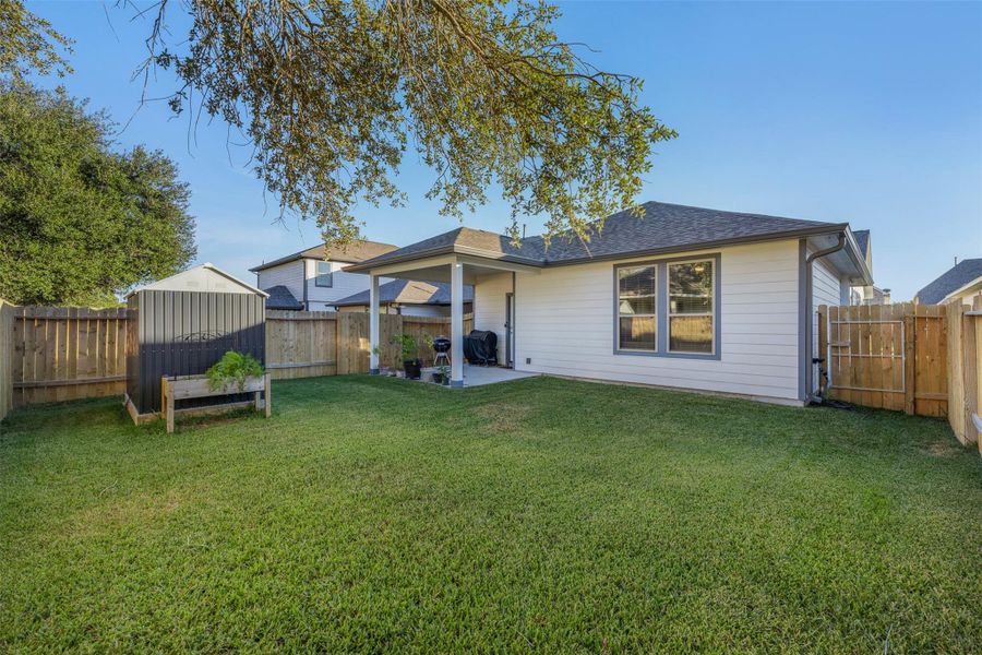 Spacious backyard with a cozy covered porch, perfect for outdoor relaxation and entertaining.