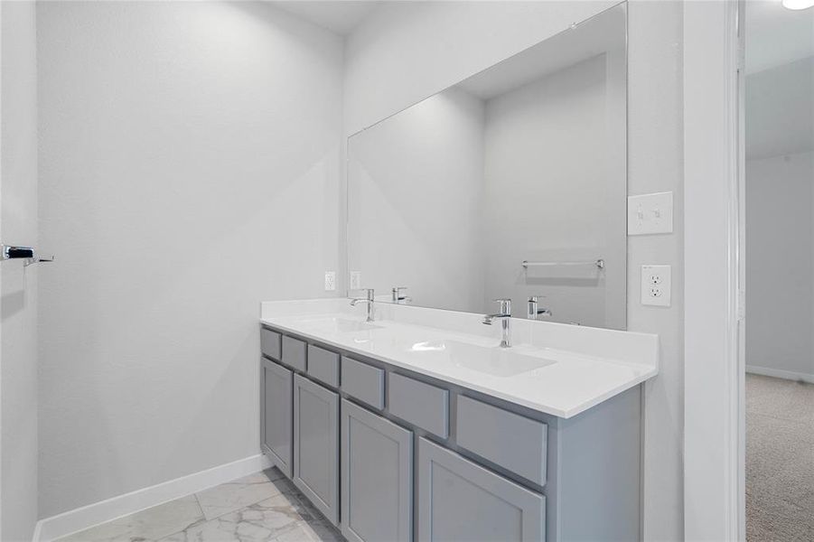 This primary bathroom is definitely move-in ready! Featuring a framed walk-in shower with tile surround, separate garden tub for soaking after a long day with custom tile detailing, grey cabinets with light countertops, spacious walk-in closet with shelving, high ceilings, custom paint, sleek and modern finishes.