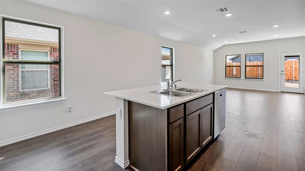 Kitchen featuring dark wood finish cabinetry, an island with sink, recessed lighting, dark wood-type flooring, and healthy amount of natural light Kitchen featuring dark wood finish cabinetry, an island with sink, recessed lighting, dark wood-type flooring, and healthy amount of natural light