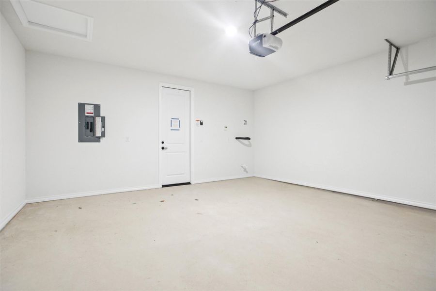 Garage featuring electric panel and a garage door opener