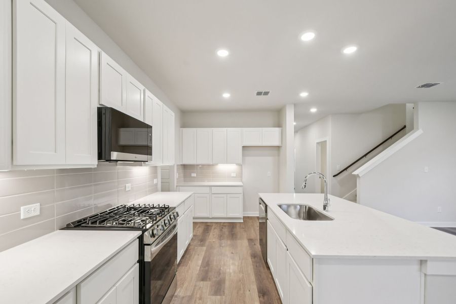 A kitchen with white cabinets.