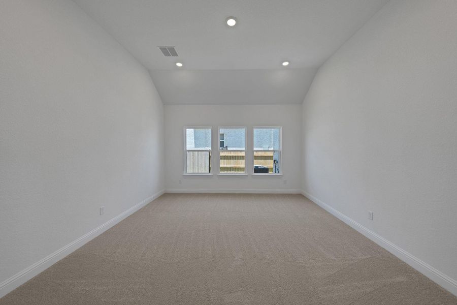 Empty room with vaulted ceiling, light carpet, and recessed lighting