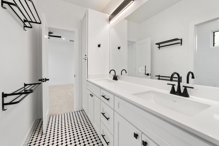 Bathroom with double vanity and baseboards