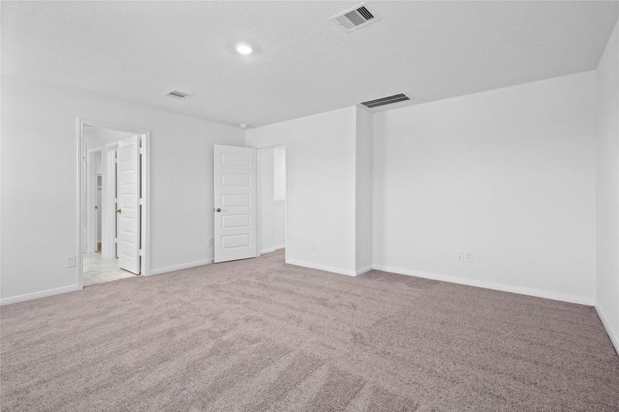 Additional view of the primary bedroom looking towards the primary bathroom. Additional view of the primary bedroom looking towards the primary bathroom.