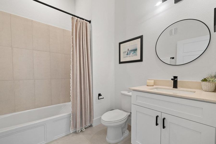 Bathroom with shower / tub combo with curtain, vanity, and light tile patterned floors