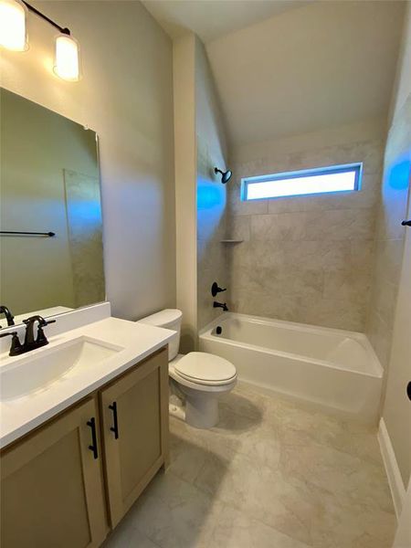 Bath 2 downstairs with Quartz counters, 12x24 tile, and a window for natural light