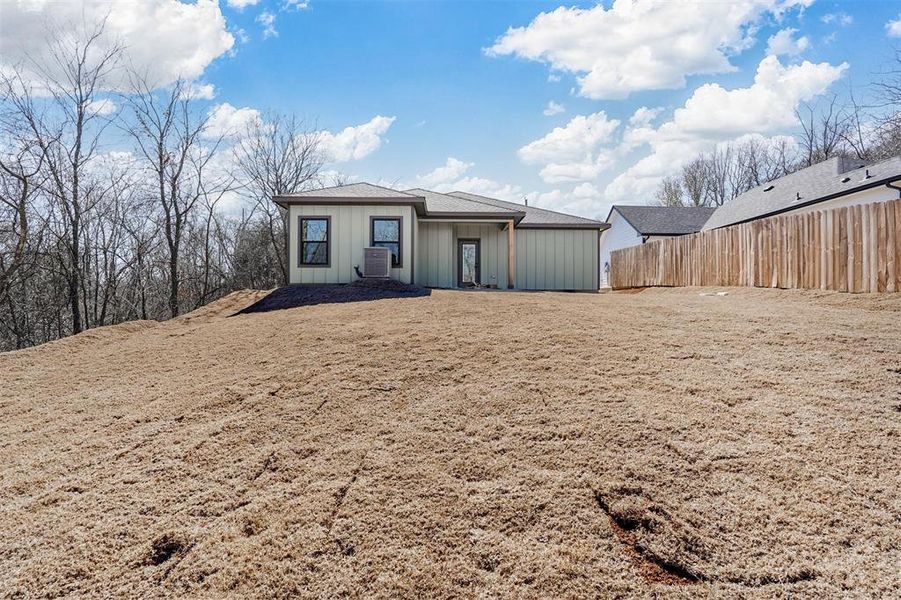 View of front of house with board and batten siding and fence