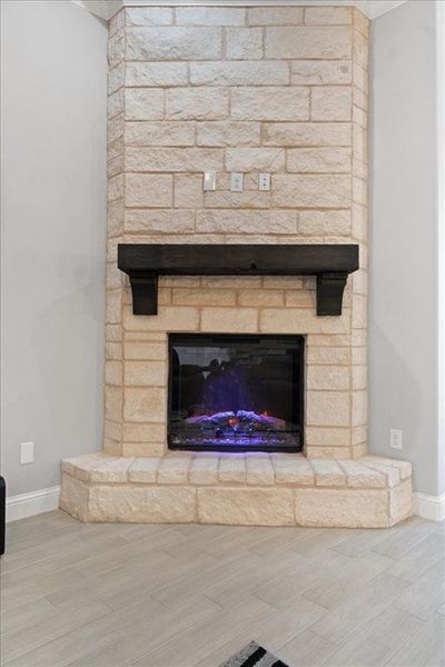 Interior details with wood tiled floor, a fireplace, and baseboards