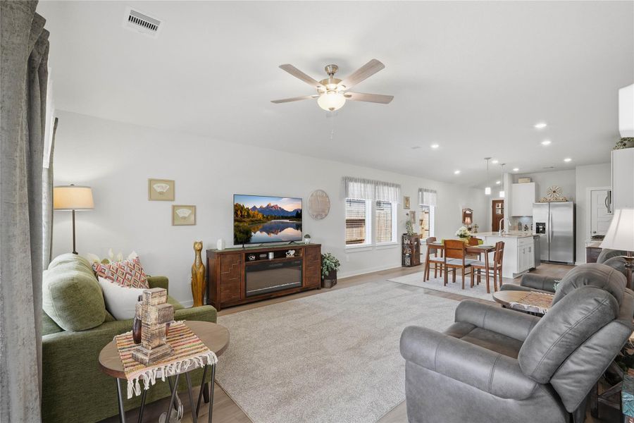 The living, dining, and kitchen areas flow seamlessly together, creating an open and inviting space.