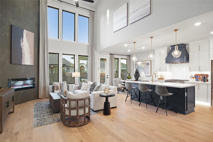 Living room featuring light wood finished floors, a high ceiling, and recessed lighting