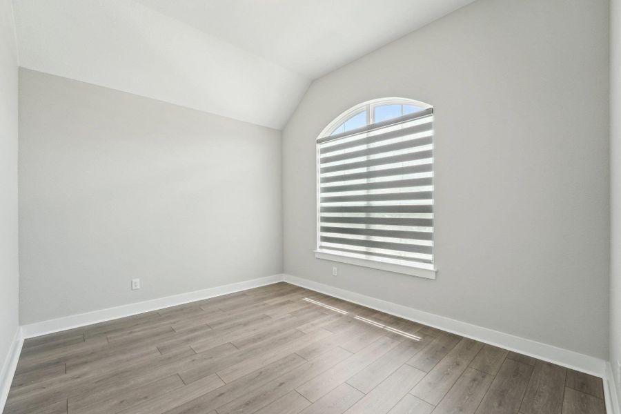 Spare room featuring lofted ceiling and wood finished floors Spare room featuring lofted ceiling and wood finished floors
