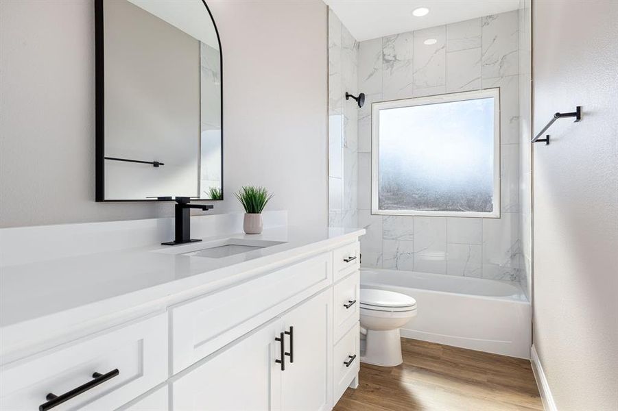 Full bathroom with toilet, hardwood / wood-style floors, vanity, and tiled shower / bath