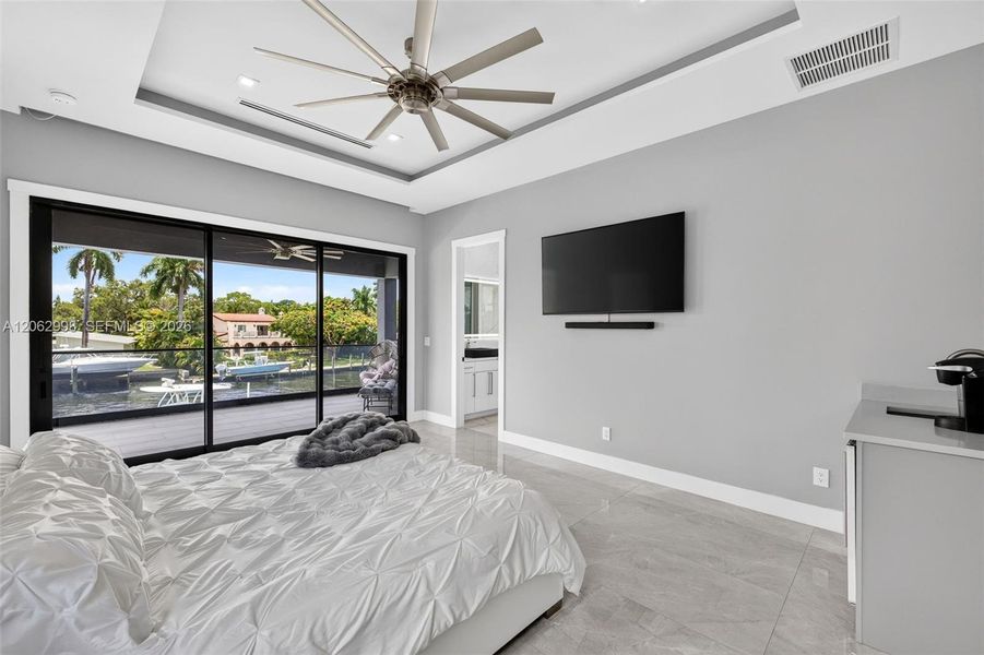 Primary bedroom suite w/ french doors, morning bar, en suite walk in closet and spa bathroom. Sliders lead to private balcony looking down the river