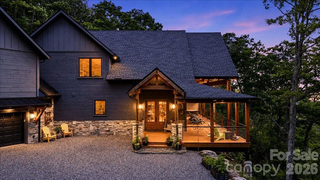 Twilight view of front door and garage