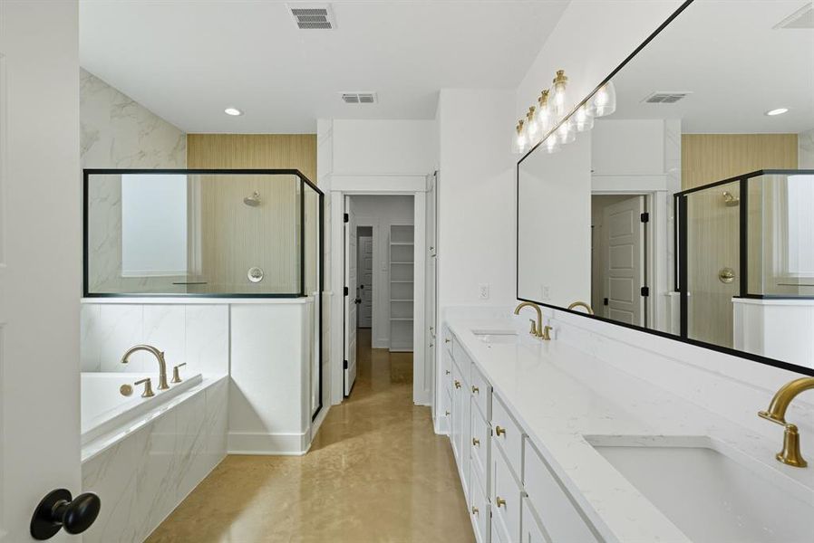Full bath with a stall shower, a garden tub, double vanity, a walk in closet, and finished concrete floors