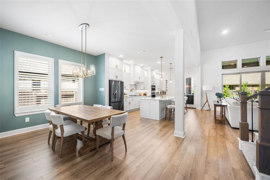 Dining area with updated light fixture and plantation shutters.