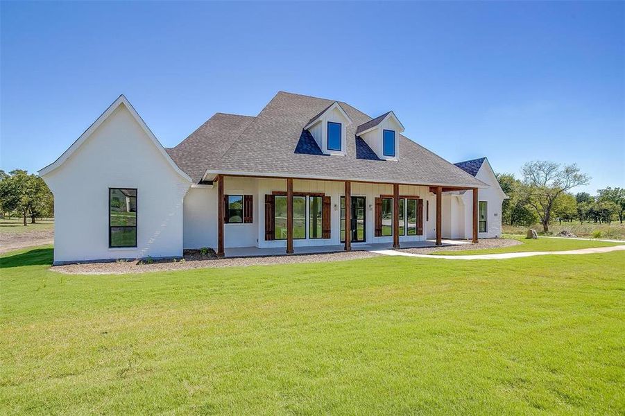 View of front of house with a front yard and french doors