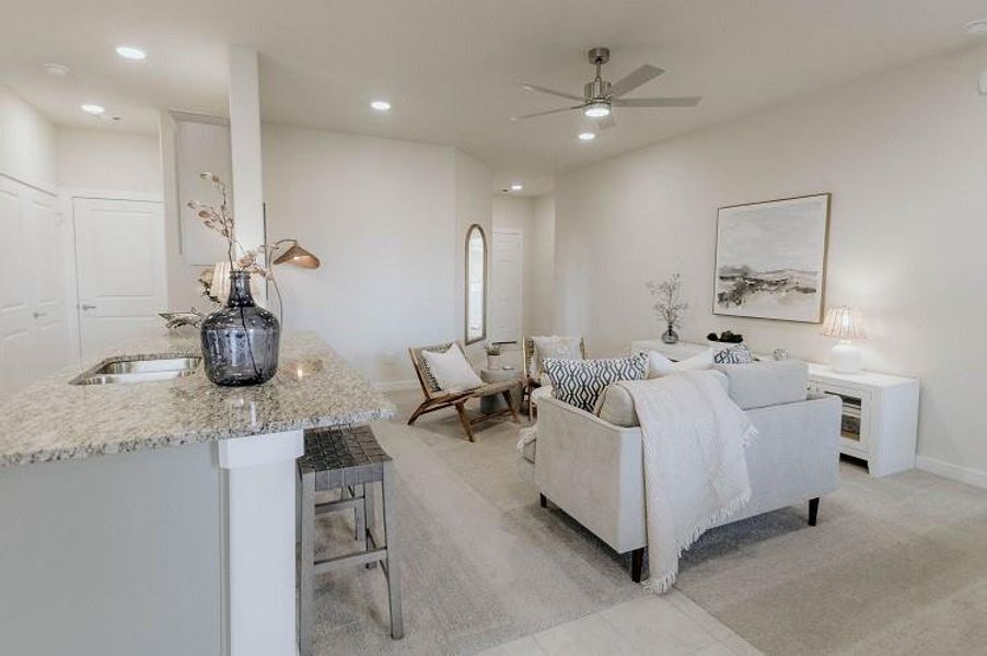 Living room with ceiling fan, recessed lighting, and light colored carpet Living room with ceiling fan, recessed lighting, and light colored carpet