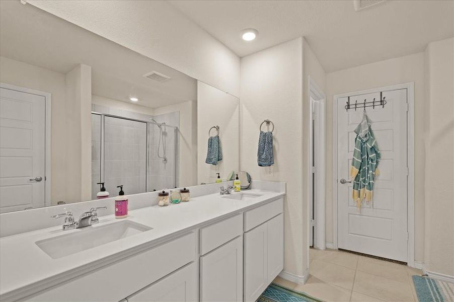 Bathroom with tile patterned flooring, vanity, and an enclosed shower