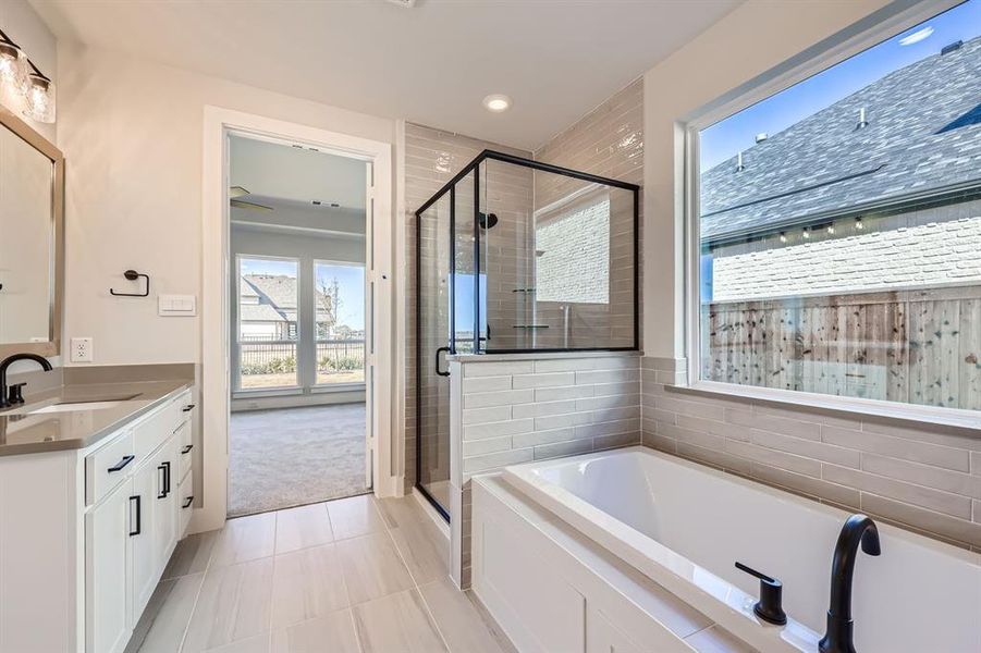 Bathroom featuring vanity, tile patterned floors, and independent shower and bath