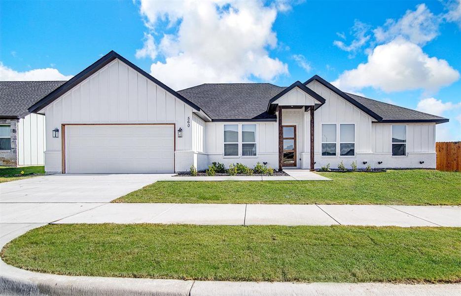 Modern farmhouse style home with a front yard and a garage