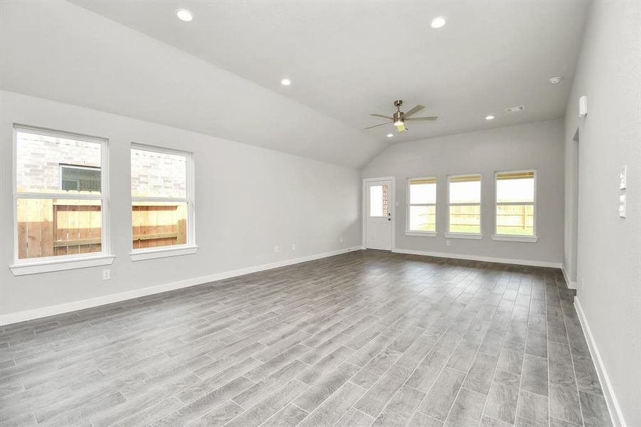 Family room flooded with natural light through the expansive windows. The premium tile flooring adds a touch of luxury to the space, creating the perfect setting for relaxing moments and cherished gatherings with loved ones