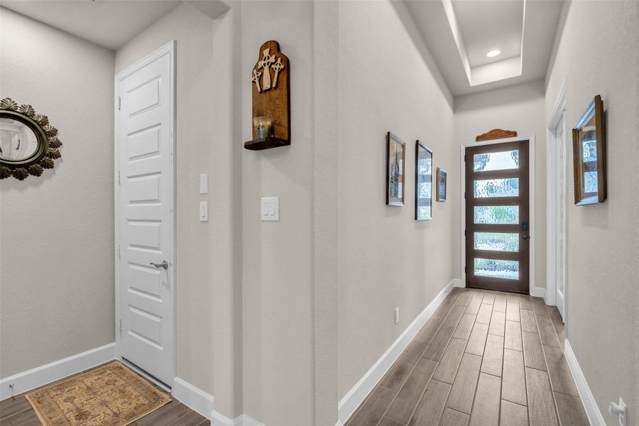 The striking front entry with tray ceiling and impressive glass and wood front door. The striking front entry with tray ceiling and impressive glass and wood front door.