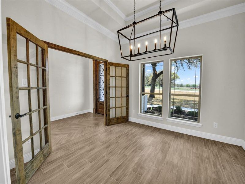 Unfurnished room featuring baseboards, crown molding, wood finished floors, and french doors Unfurnished room featuring baseboards, crown molding, wood finished floors, and french doors