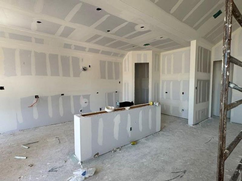 A spacious kitchen area undergoing construction, showcasing recessed lighting and a central island. A spacious kitchen area undergoing construction, showcasing recessed lighting and a central island.