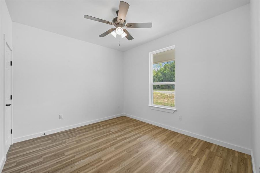Unfurnished room featuring light wood-style flooring and a ceiling fan Unfurnished room featuring light wood-style flooring and a ceiling fan