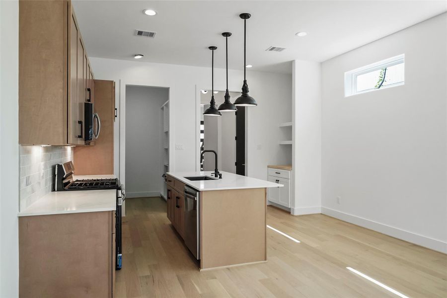 Modern kitchen with stylish lighting and a built-in wine bar. Modern kitchen with stylish lighting and a built-in wine bar.