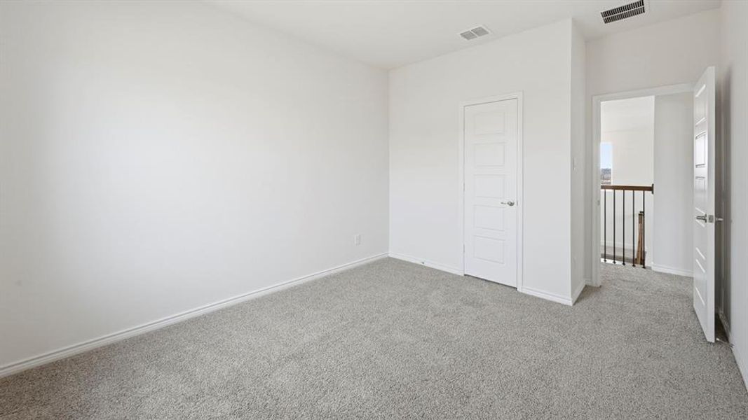 Carpeted room featuring light gray carpeting, white baseboards, and white walls Carpeted room featuring light gray carpeting, white baseboards, and white walls