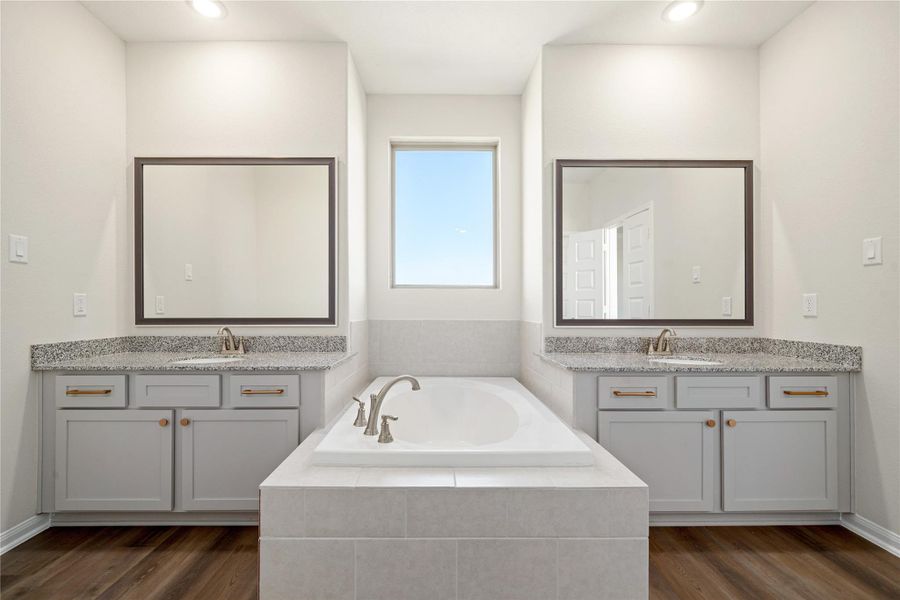 The primary bath features clean, modern finishes with a double-sink vanity, soaking tub, and separate shower. Soft tones and sleek lines create a relaxing, spa-inspired atmosphere. The primary bath features clean, modern finishes with a double-sink vanity, soaking tub, and separate shower. Soft tones and sleek lines create a relaxing, spa-inspired atmosphere.