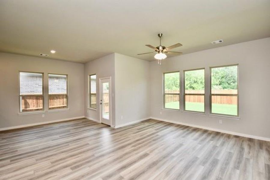 Family room has a healthy amount of natural light, wood finished floors, a ceiling fan, and recessed lighting Family room has a healthy amount of natural light, wood finished floors, a ceiling fan, and recessed lighting