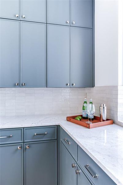 Kitchen with backsplash and light stone counters