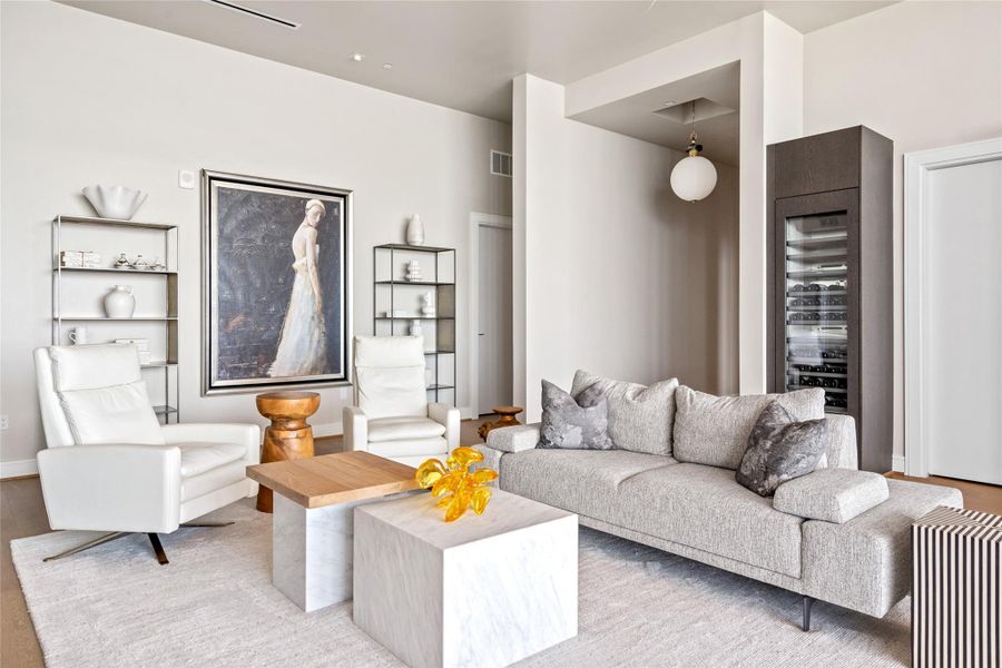 This contemporary, airy room showcases hardwood floors, soaring ceilings, and a serene neutral color palette.