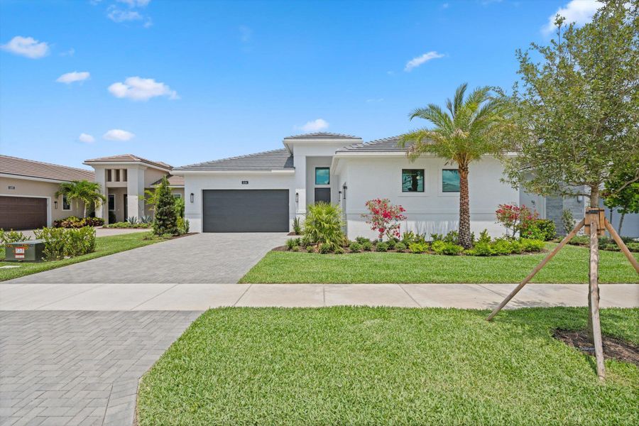 Front exterior of a new home in Cresswind Palm Beach at Westlake, Westlake, FL, highlighting curb appeal (Image 30). Front exterior of a new home in Cresswind Palm Beach at Westlake, Westlake, FL, highlighting curb appeal (Image 30).