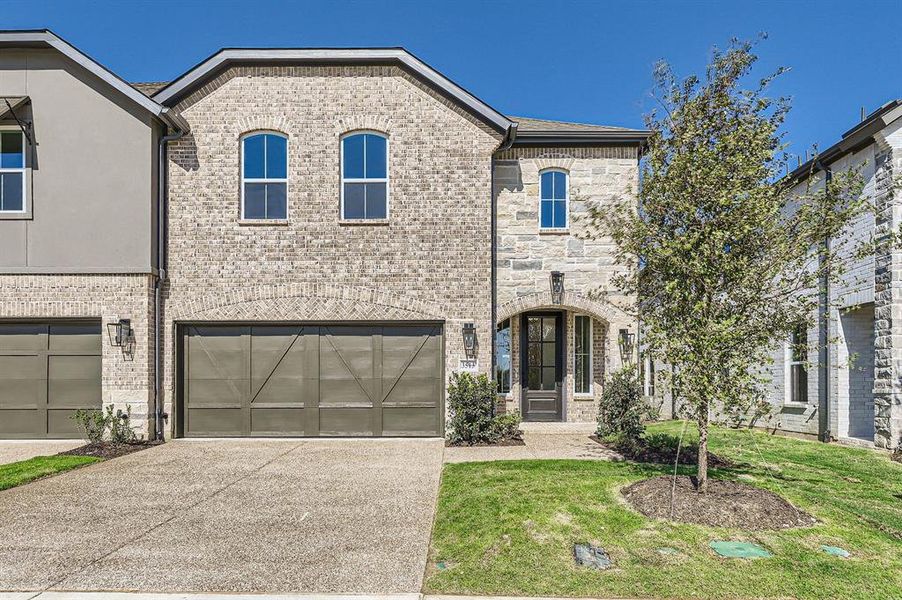 French country style house featuring a front yard and a garage